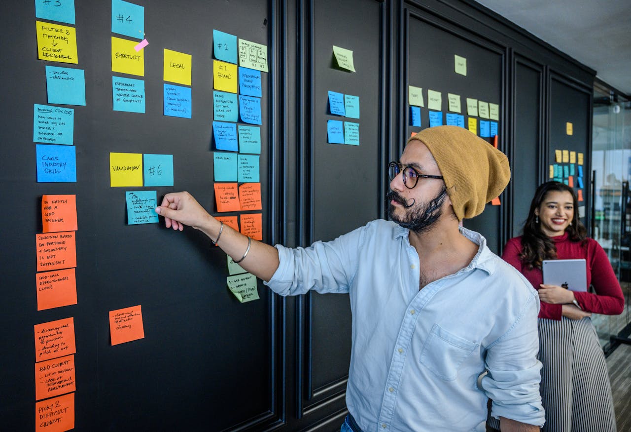 Business professionals collaborating with sticky notes on an office wall, fostering teamwork.
