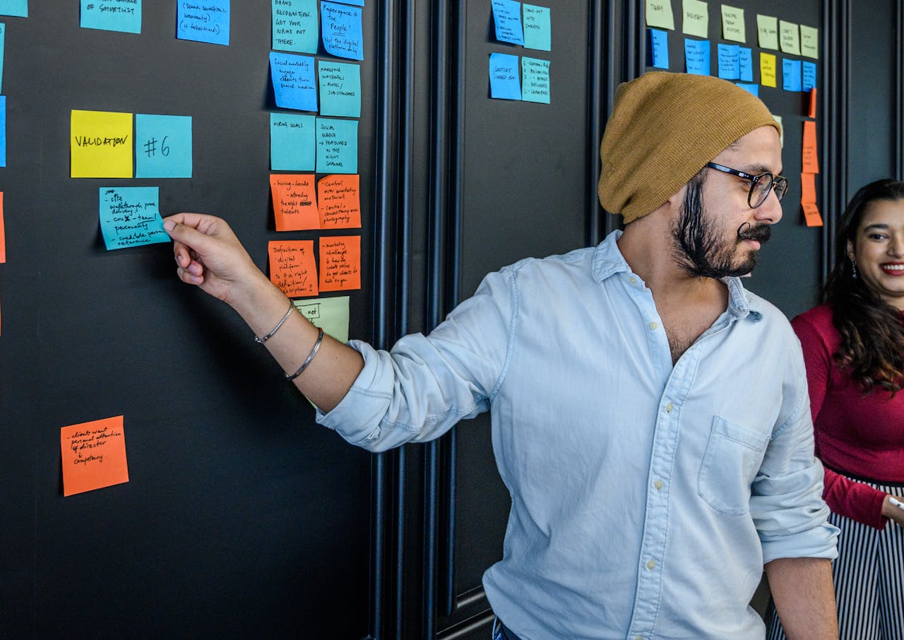 Young professionals collaborate using sticky notes during a business meeting in a modern office.